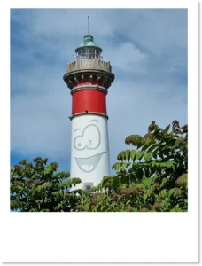 Montage photo du phare de Ouistreham qui arbore un visage cartoonesque joyeux
