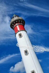Montage photo du phare de Ouistreham hissé par une corde dessinée