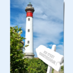 Montage photo du phare de Ouistreham vers lequel pointe une pancarte "Ici c'est Ouistreham !"
